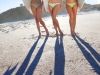Three Beautiful Women Surfers In Bikinis With Surfboards At Beac